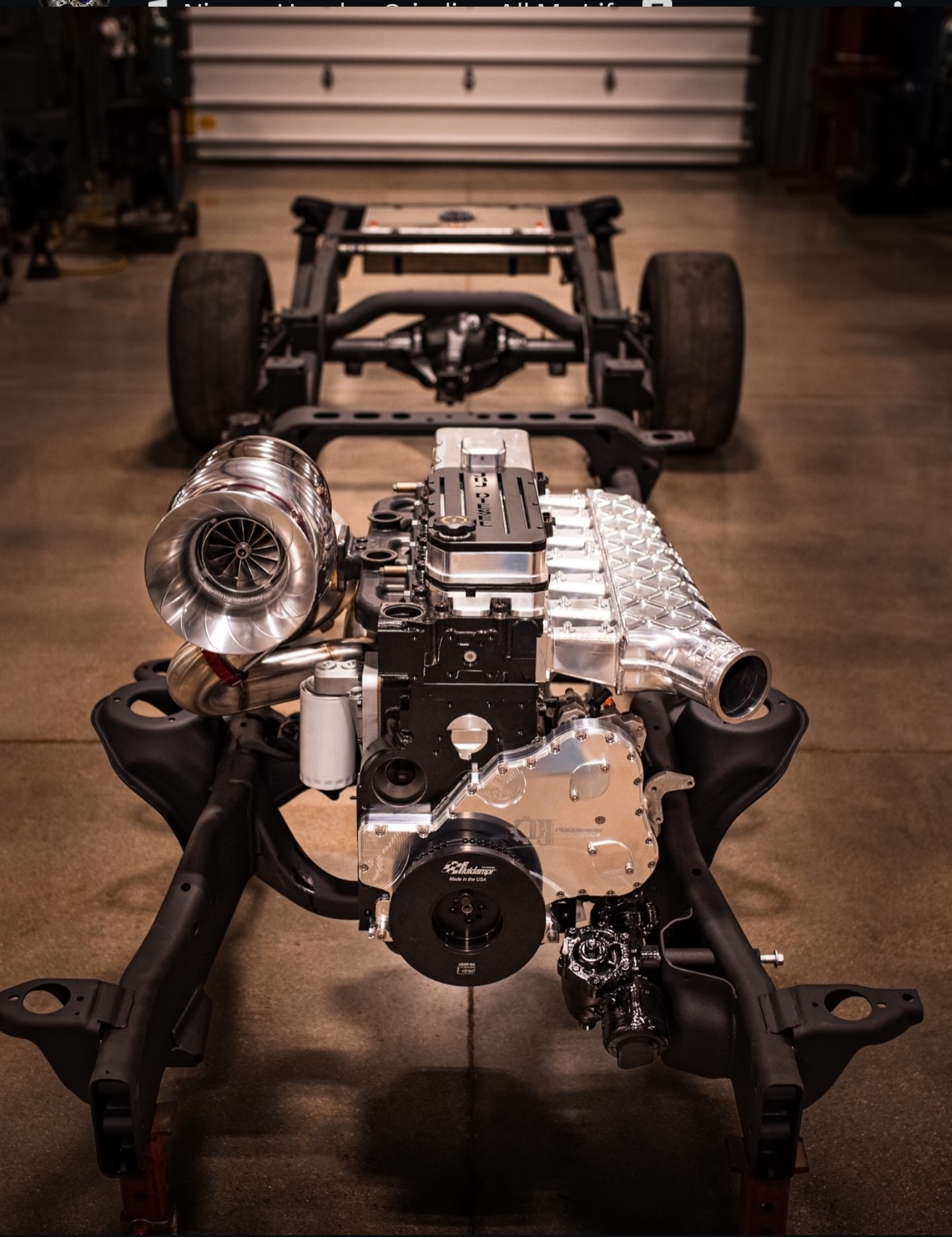 Custom turbocharged diesel engine assembly on a chassis inside the JBJ Diesel shop