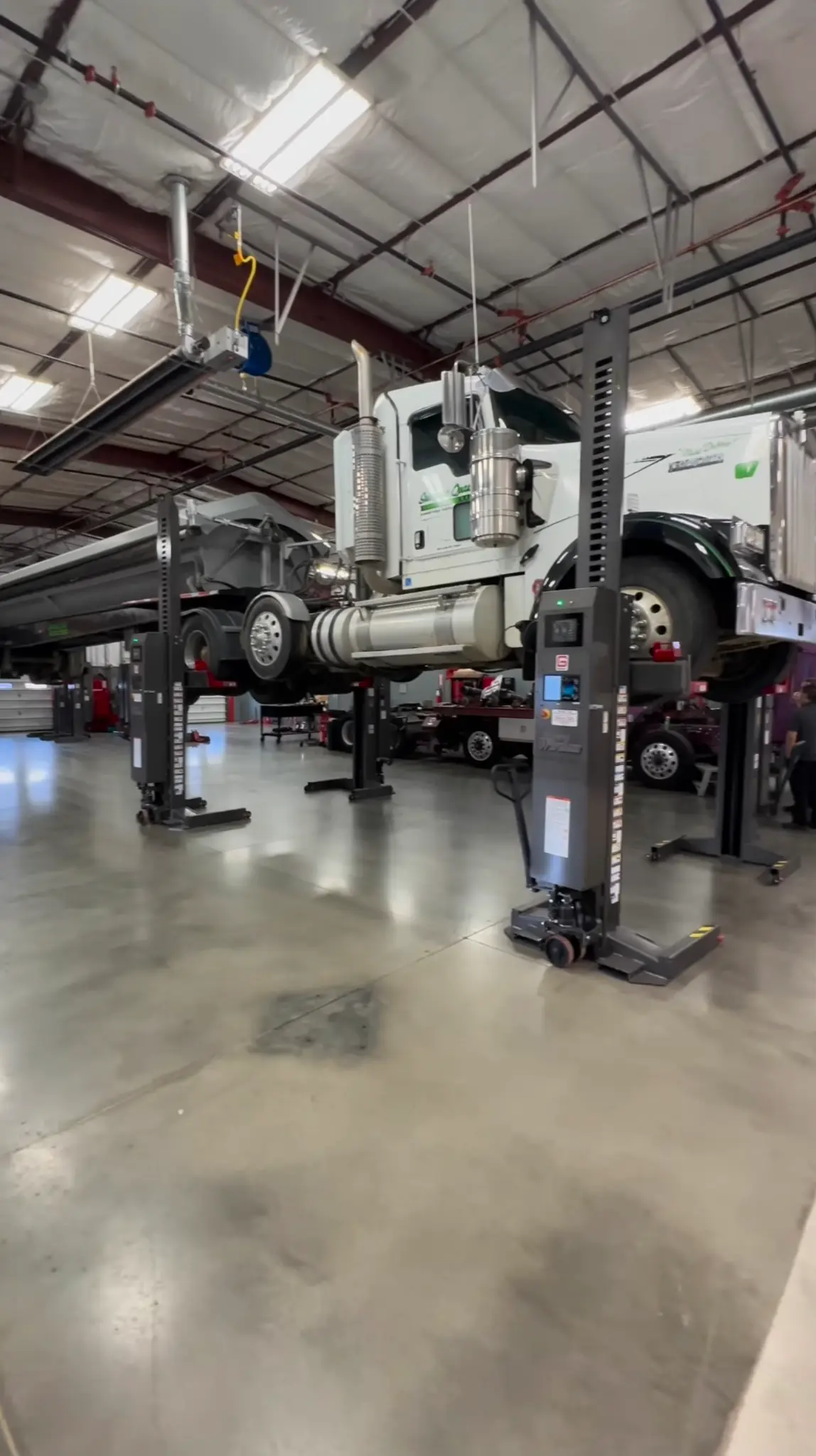 Heavy-duty truck raised for service inside the shop