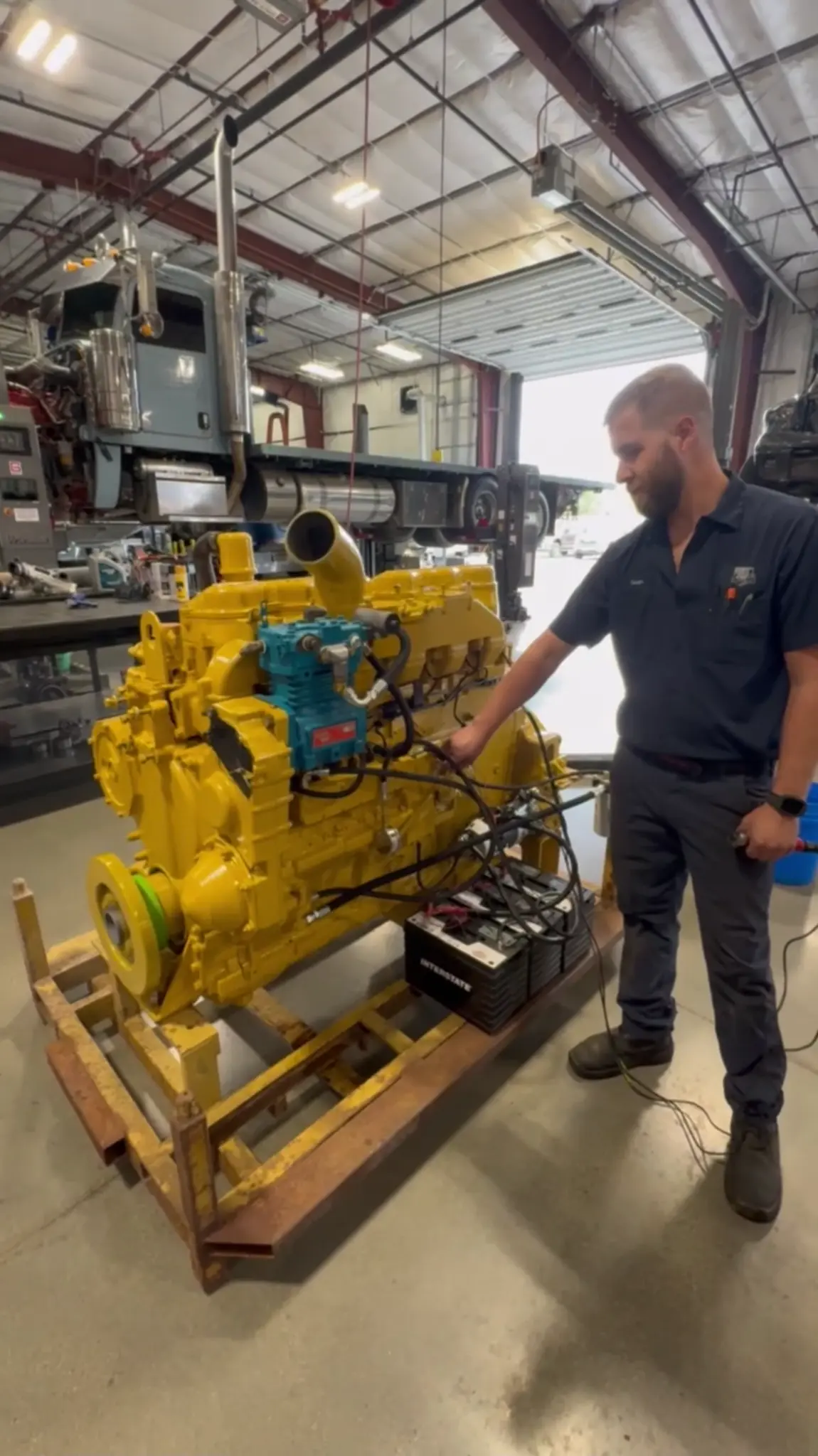 Technician working beside a diesel engine in the shop