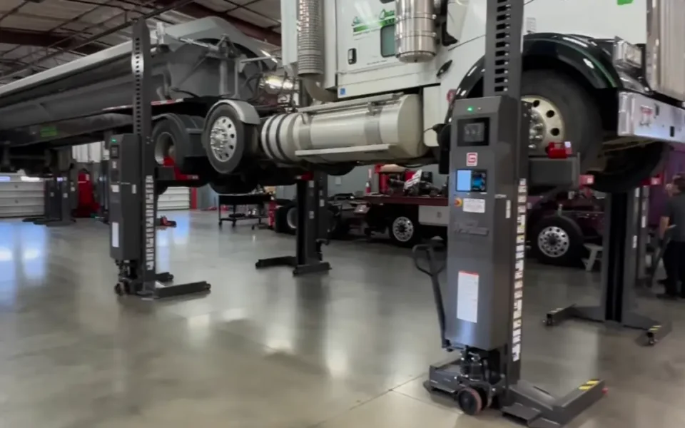 Commercial truck raised on service lifts inside the JBJ Diesel shop